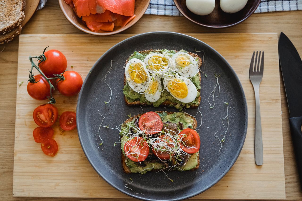 Delicious avocado toast topped with fresh eggs and tomatoes, perfect for a healthy breakfast or lunch.